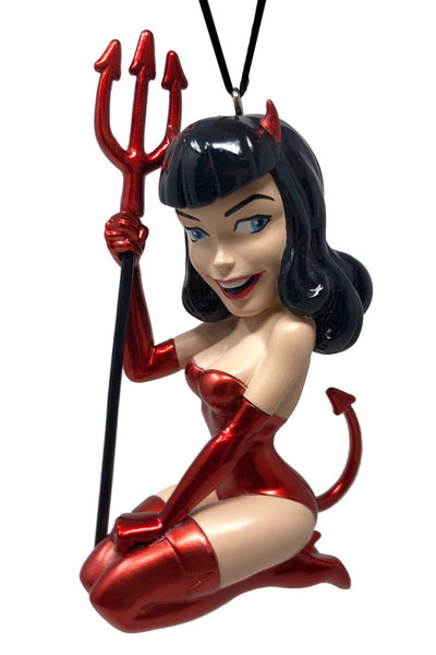 “Devil Girl" painted resin ornament featuring Bettie Page wearing metallic red devil costume with red thigh high boots, devil ears and tail, and holding a matching red trident. Shown from front