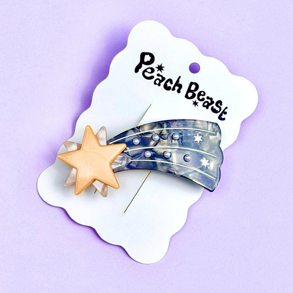 french style hair clip made of plant-based acetate in the shape of a shooting star with metallic gold and marbled gold star & marbled blue trail with white pearls. Shown on backing card