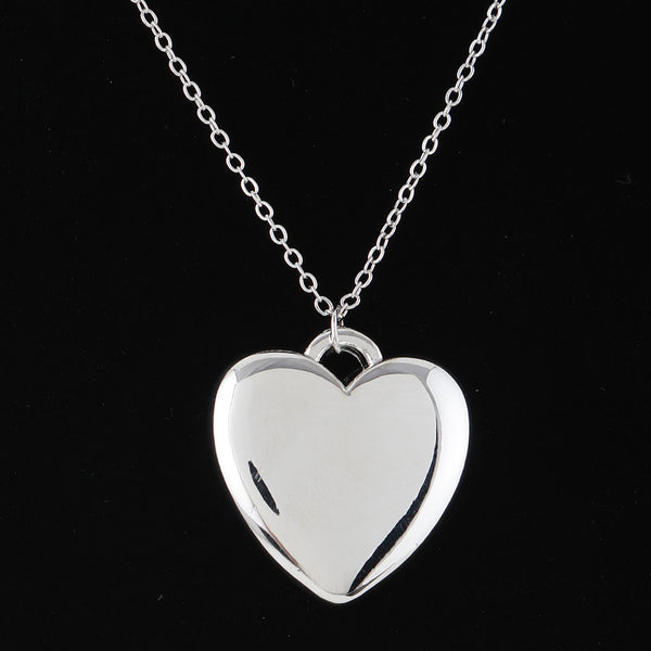 large silver metal heart pendant on an 18" silver metal link style chain. Shown in close up