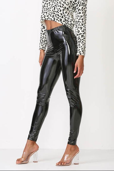 high-waisted shiny black vinyl leggings with elastic waistband, shown on model from side