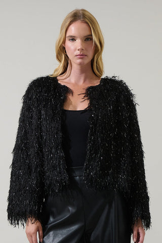 model wearing black shaggy faux fur cropped jacket with metallic fringe throughout. Jacket is collarless. Shown from front