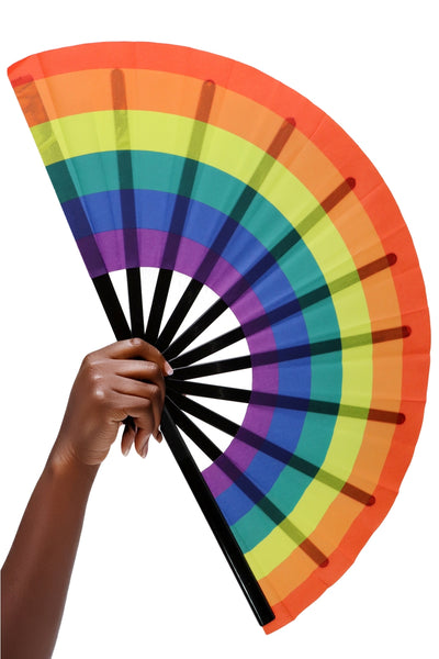 A giant 13” wide rainbow printed fabric folding fan with black plastic ribs. Seen open from front held
