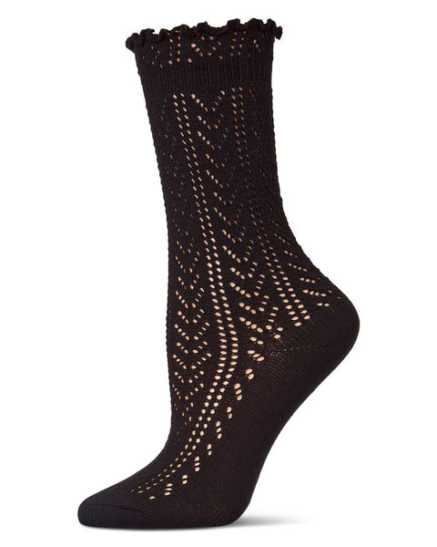 Black socks with textured knit pointelle pattern and ruffled cuff on a white background shown worn by mannequin foot
