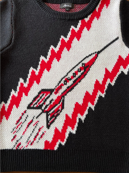 fitted acrylic short sleeve sweater with a retro looking rocket ship on a red, white, and black background. Shown lying flat in close up