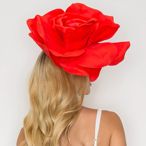 model wearing oversized red satin rose fascinator. Shown from back