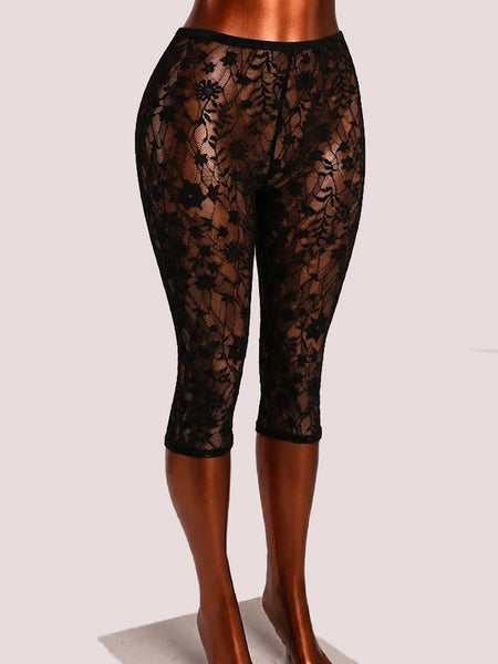 Black floral patterned lace high-waist capri length leggings displayed on a mannequin leg form against a light gray studio background. Shown from three quarter angle
