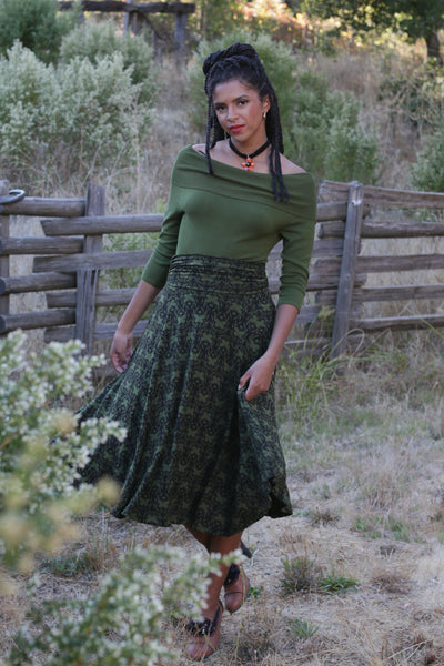 green and black patterned swing skirt worn by a model in an outdoor setting