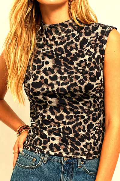Person wearing a leopard print sleeveless top and blue jeans against a plain background