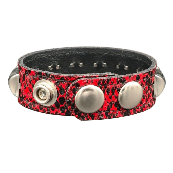 faux leather black and red textured snakeskin 1/2" wide cuff with one row of silver pyramid studs. Shown from back to display snap closures