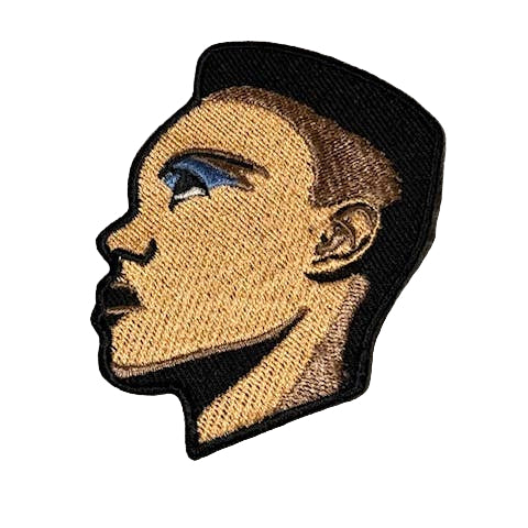embroidered patch of the face of Grace Jones seen from a side angle with close cropped haircut and blue angular eye makeup