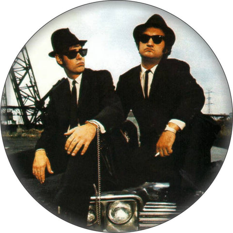 1.25" round pinback button featuring Dan Aykroyd and John Belushi as the Blues Brothers sitting on a car hood