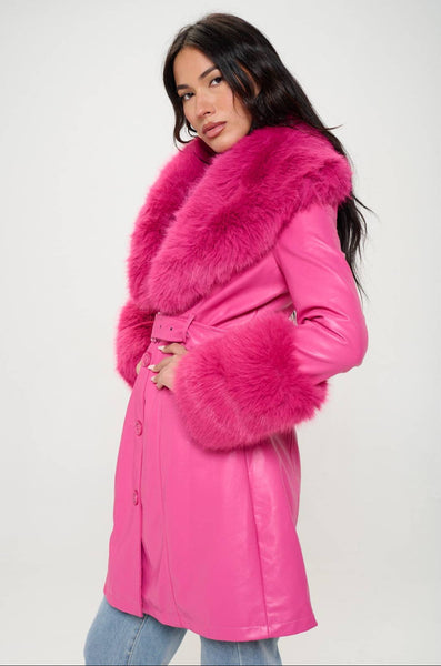 Model wearing hot pink faux fur trench coat with oversized hot pink faux fur shawl collar and wide cuffs. Shown buttoned up from side