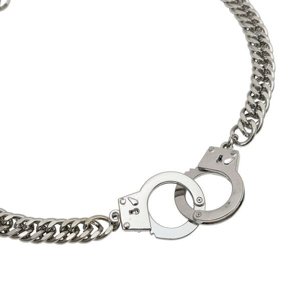 silver stainless steel cuban link style necklace with pair of matching handcuffs in center. Shown flat in close up of handcuffs