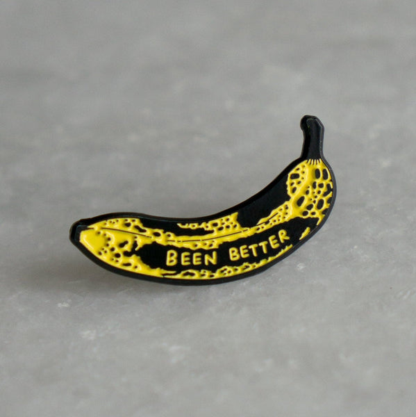 bruised banana-shaped enamel pin with ' BEEN BETTER' text on a white background