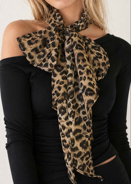 Long rectangular chiffon brown leopard print scarf worn by model around neck in bow