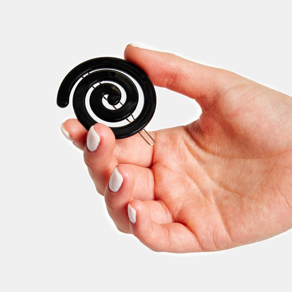 black acetate ball-and-clasp barrette in a rounded spiral shape. Shown held for scale
