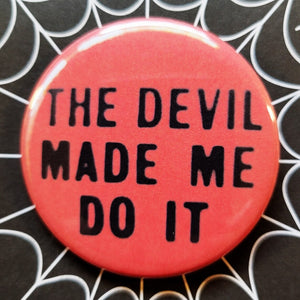 1.25” round button “THE DEVIL MADE ME DO IT” in black lettering on red background 