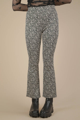 black and white zebra print ponte knit high-waisted pants with elastic waistband and slightly flared legs. Shown from front