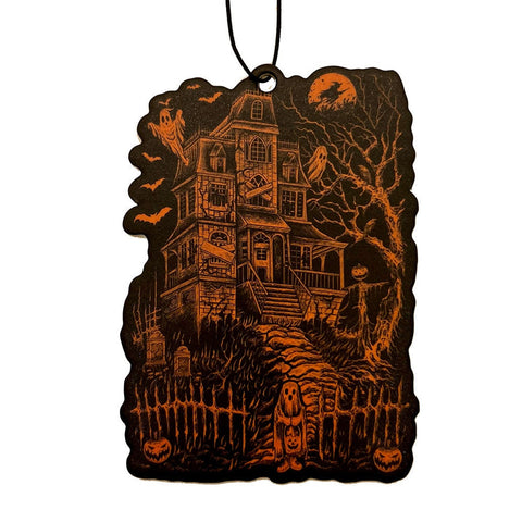Halloween-themed air freshener with a haunted house design in orange on a black background