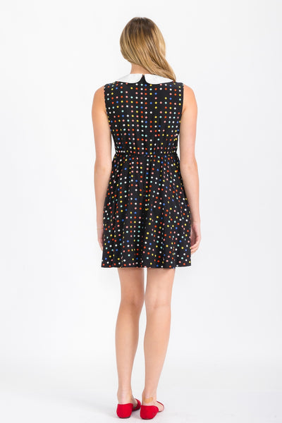 model wearing black sleeveless shift dress with pink, yellow, red, blue, and white multicolor polka dot pattern and white Peter Pan collar. Shown from back
