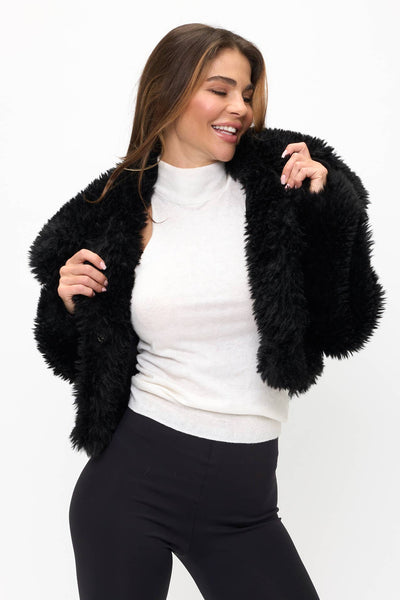 model wearing a black faux fur fluffy cropped jacket with oversized round collar. Shown from front