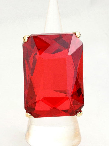  rectangular faceted red plastic jewel set on a gold metal ring with an adjustable segmented stretch band