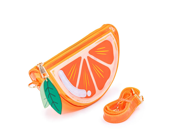 orange vinyl purse shaped like slice of orange with zip closure top, zipper pulls shaped like green leaves, and removable matching strap. Shown from side with strap shown detached