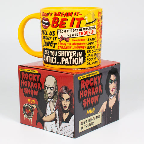 Yellow mug with quotes from the Rocky Horror Picture Show shown on top of its cardboard gift box