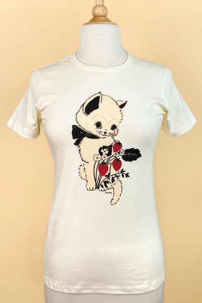 Fitted off-white t-shirt with printed image of a cream-colored kitten with black bow around its neck alongside a blossoming strawberry plant with three berries. Shown on a dress form from the front