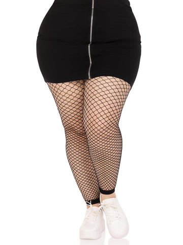 Plus size model wearing black industrial fishnet footless tights with mini skirt and white running shoes shown from font