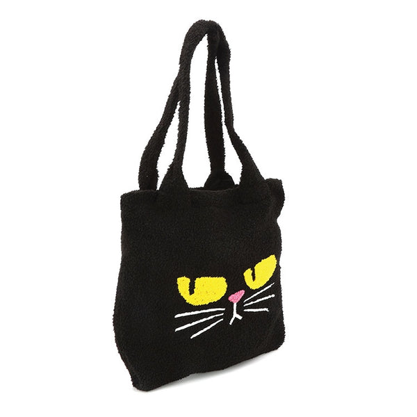 black teddy/sherpa fuzzy fabric tote bag with embroidery details of grumpy looking yellow eyes, pink nose, and white whiskers. Bag has matching fuzzy shoulder straps. Shown from side