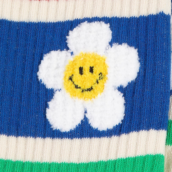 Detail shot of knit in fuzzy design of a white daisy with yellow happy face in the middle