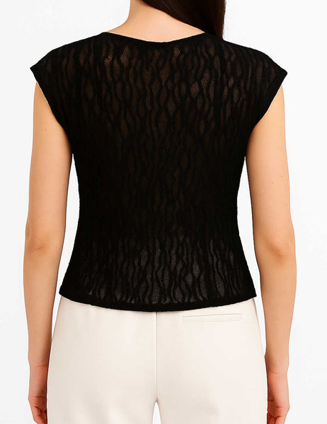 model wearing a black floral patterned lace top with round neckline, short cap sleeves, and vertical ruffle details. Shown from back