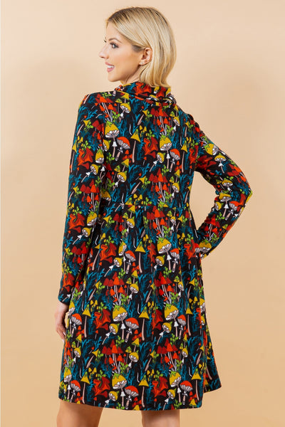 black and multicolored mushroom and forest flora print on a long sleeve fit & flare sweater dress with a cowl neck. Seen on a model in a 3/4 shot from behind 