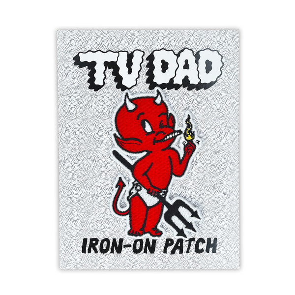 embroidered patch of little devil with black pitchfork and white diaper/loincloth holding a cigarette in his mouth and a flame in one hand. Shown on branded backing card