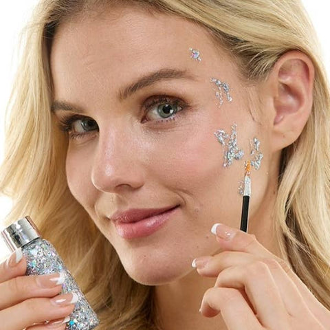 Woman applying glittery silver makeup with a brush and bottle