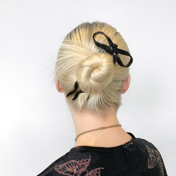 5 1/2" black acetate bow shaped hairpin. Shown in model's hair