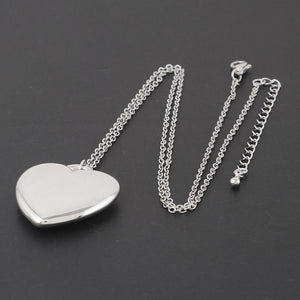 large silver metal heart pendant on an 18" silver metal link style chain. Shown flat