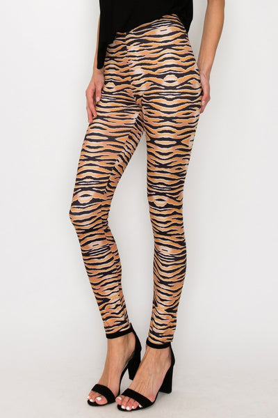 model wearing high-waisted, full-length brushed fiber knit leggings with a black and orange tiger stripe pattern. Shown from side