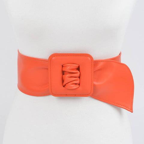 bright orange matte finish faux leather belt with a large square self buckle on dress form on a white background