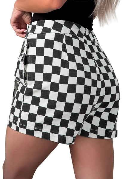 Model wearing black and white checker print cotton twill mini skort with pockets. Shown from back