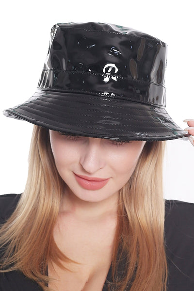Person wearing a black patent leather bucket hat