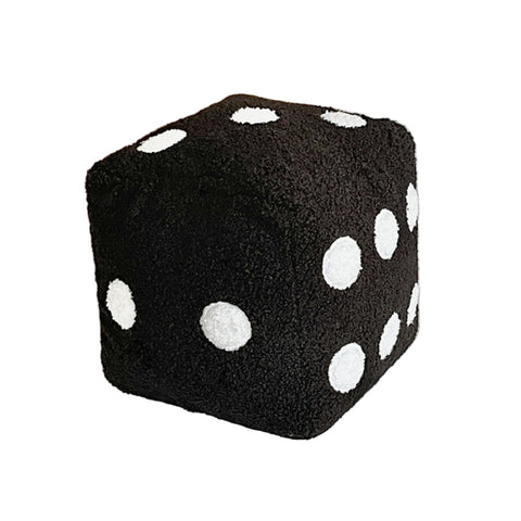 Black dice-shaped pillow with white dots on a bed