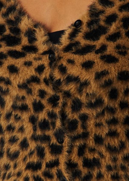 Woman wearing a leopard print sweater in a faux mohair material with long sleeves, slight v-neckline, and matte black plastic buttons. Shown from front in close up