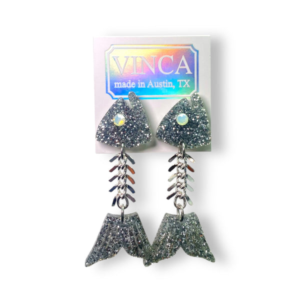 laser-cut silver glitter acrylic fish bone drop earrings with acrylic heads and tails with frosted rhinestone for each eye connected with bone-like chain