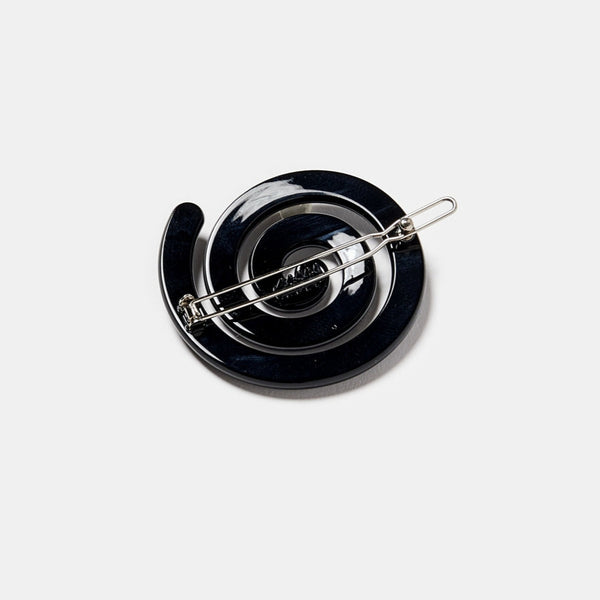 black acetate ball-and-clasp barrette in a rounded spiral shape. Shown from the back to display clasp hardware
