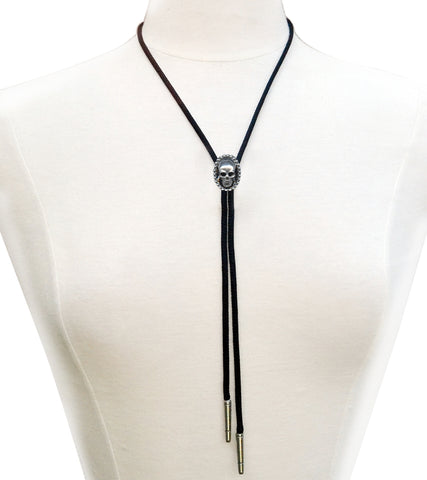 Silver metal skull pendant bolo tie with black rayon cord and silver metal tips. Shown on a dress form