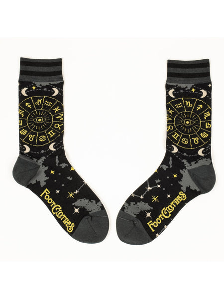 Unisex crew socks with a yellow Astrology wheel illustration on the outer side of each sock and constellations, stars, moons, and clouds in grey/white/gold lurex thread as an all over pattern on a black background. Shown flat with outer side on both sock shown