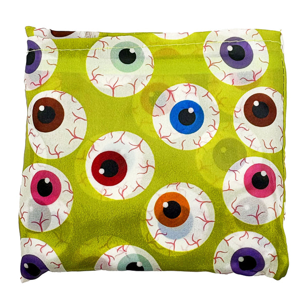 A lime green reusable nylon tote bag with an all-over pattern of large cartoonish eyeballs in various colors, shown folded into its attached pouch on white background
