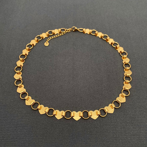 16" necklace made of linked hammered texture gold hearts connected with large gold jump rings. Shown flat from back